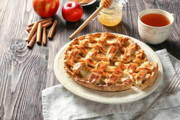 Plate with tasty apple pie on wooden table