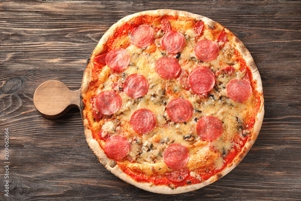 Wooden board with tasty pizza on table
