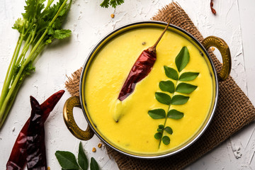 Wall Mural - Indian Cuisine Kadhi - Vegetarian Curry Made of Buttermilk And Chick Pea Flour. served in a bowl or Karahi over moody background, selective focus