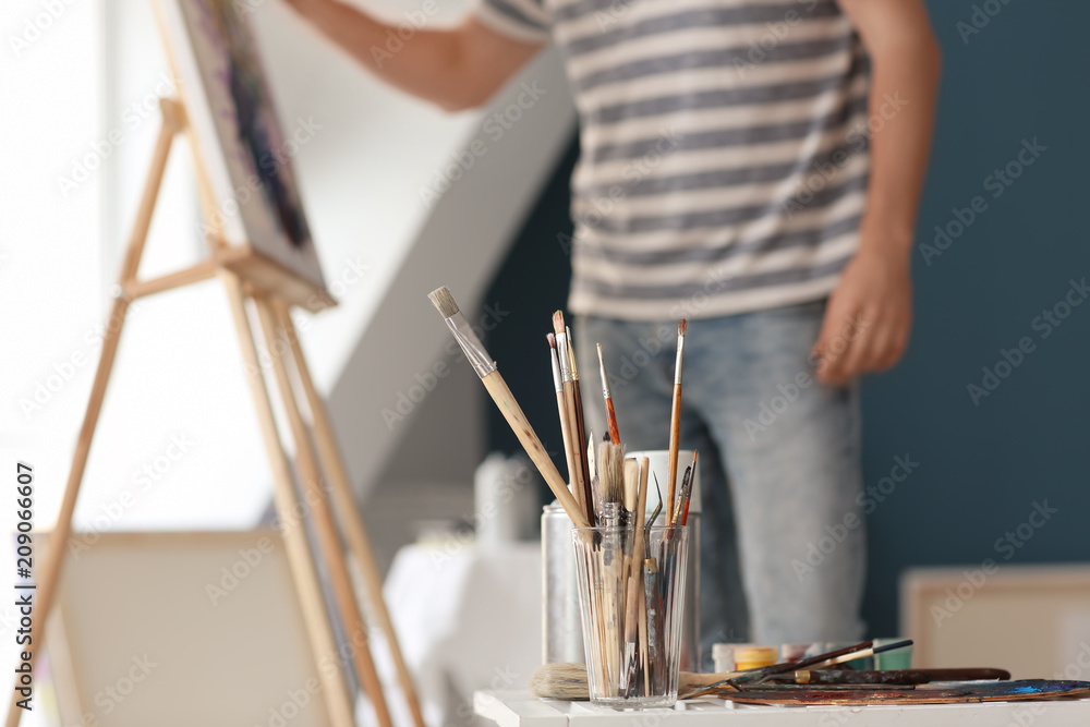 Table with paint tools in artist's workshop