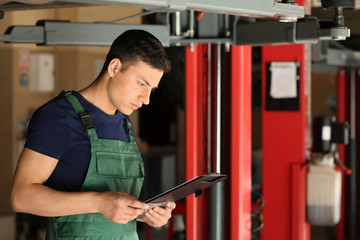 Sticker - Young auto mechanic with clipboard near car in service center