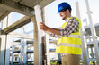 © NDABCREATIVITY - Portrait of male site contractor engineer with hard hat holding blue print paper