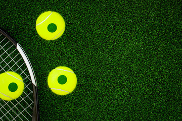 Wall Mural - tennis racket on green background top view