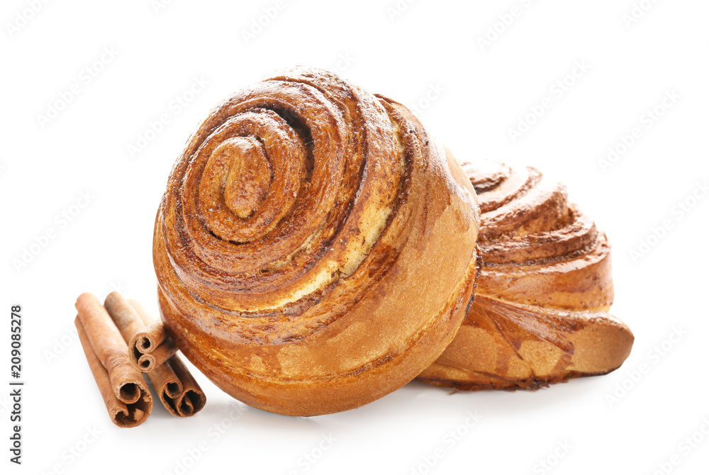 Delicious buns and cinnamon sticks on white background