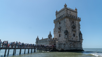 Wall Mural - Tourists in queue to visit the Belem tower at the bank of Tejo River in Lisbon, Portugal