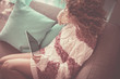 lonely lady at home with curly brown hair watching technology tablet connected to internet to check social media or work or movie. wifi and homeworking concept. woman sitting on sofa