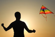 © ruslanshug - young man with colorful flying kite on summer warm sunset outdoors