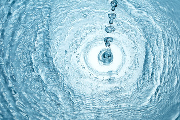 Background of blue clear water in motion with waves, pouring with splash