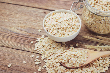 Wall Mural - Oatmeal or oat flakes in bowl on wooden table. Toned.