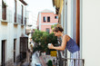 © JavierPardina/Stocksy - Woman having breakfast on the balcony, Granada, Spain.