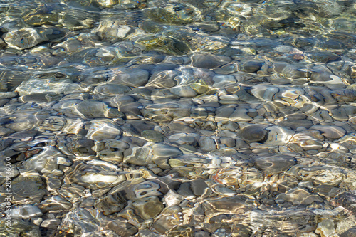Fototapeta Pebbles in the clear sea water