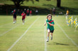 © Angela Lumsden/Stocksy - Child with a determined expression winning a running race