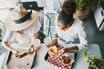 Wall Mural - two friends eating healthy vegan food at restaurant together