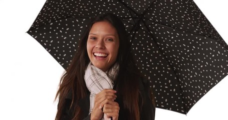 Wall Mural - Caucasian millennial female with polka dot umbrella on white background, Beautiful woman in her 20s spinning umbrella in studio, 4k