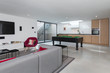 © phillipsvisuals/Stocksy - Basement apartment modern decor with pool table at one end.