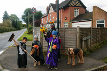 A Group Of Children Walk To A Halloween Party.