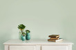 © Gillian Vann/Stocksy - hall table with plant, books and blank wall