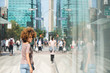 © Lauren Naefe/Stocksy - Young woman in headphones walking in the city