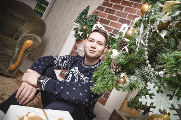 Handsome guy in the room decorated for Christmas