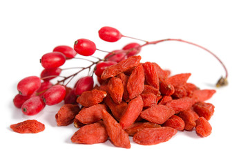 Wall Mural - Branch of ripe red barberries and dried goji berries isolated on white background