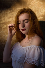 Wall Mural - Closeup portrait of sensual red haired woman in white dress posing in sun light