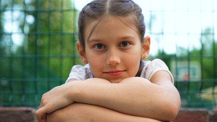 Closeup portrait of beautiful young girl. lonely bored and tired teen relaxing after roller skating in park outdoor