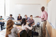 © Monkey Business - Male High School Tutor Standing At Whiteboard Teaching Class
