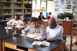 © Monkey Business - High School Tutor Sitting At Desk With Male Student In Biology Class