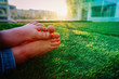 summer in the city- kids bare foot on grass in urban background