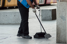 Closeup Of Man Cleaning The Front Of Train Station With Broom