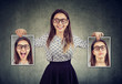 © Feodora - woman holding two different face emotion masks of herself