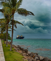 Wall Mural - The ship goes to the port, cargo ship. Stormy weather, rainy day. Port of Miami, Florida. Logistics and transportation of International Container Cargo ship in the ocean at hurricane sky.