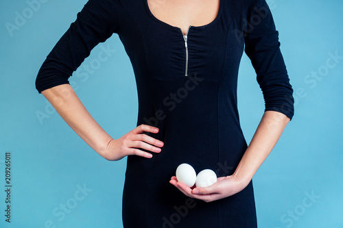 Fotografie, Obraz Eggs in the hands of a sexy girl in a black dress