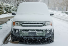 Silver SUV Car Covered In Snow And Ice. Snow Falling. Winterstorm In Spring, East Coast, USA