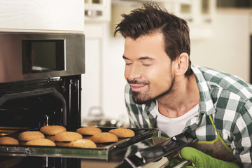 Smiling man sniffing cookies.