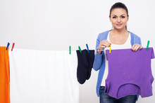 Young woman hangs clothes on dryer for clothes after washing.