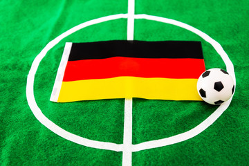 German flag and soccer ball on green grass field