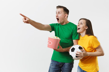 Wall Mural - European young couple, woman, man, football fans in yellow green t-shirt cheer up support team with soccer ball bucket of popcorn isolated on white background. Sport, family leisure, lifestyle concept