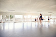 © Flamingo Images - Woman teaching girls ballet group in class