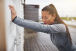 © Flamingo Images - Young Asian woman stretching against a wall before jogging