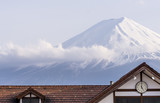 Fototapeta Uliczki - Clock that marks five o'clock with the snowy peak of Mount Fuji, Japan in the background