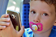 Kind spielt mit Smartphone auf einer Zugfahrt