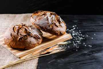 Sweet fresh bread with ingredients on black wooden background