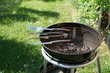 Cutlery for sausages barbecue with a charcoal barbecue in the garden
