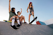 Girl practising skateboarding with friends cheering