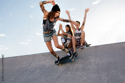 Fotografie, Obraz Skater girl rides on skateboard at skate park