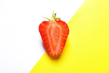  Half of ripe strawberry on color background, top view