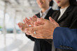 © shutterdemon - businessman and businesswoman clap their hands to congratulate the signing of an agreement or contract between their companies. success, greeting and partner concept.