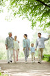 © pressmaster - Happy family of five enjoying sunny day in park while taking walk and talking