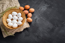 Chicken Eggs In The Basket On Black Wooden Background. Copy Space